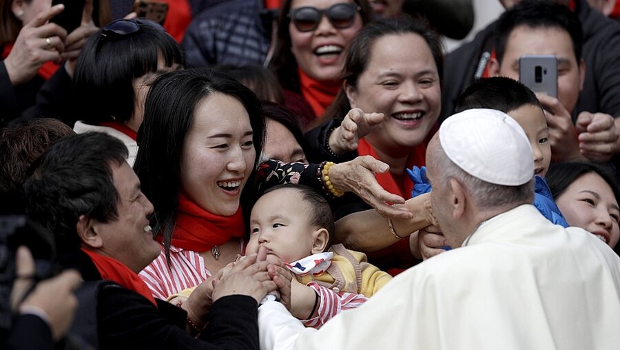 Papst Franziskus begrüßt ein Kleinkind / © Gregorio Borgia (dpa)