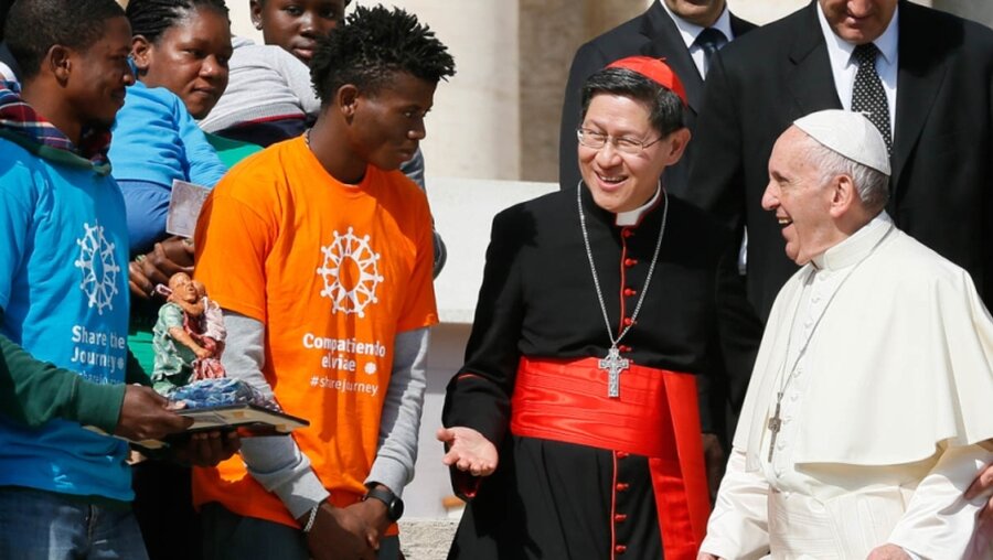 Papst Franziskus begrüßt Kardinal Luis Antonio Tagle un Migranten / © Paul Haring/CNS photo (KNA)