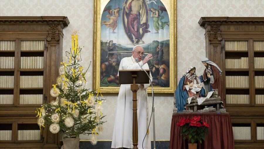 Papst Franziskus betet am 3. Januar 2021 neben einer Krippe in der Bibliothek des Apostolischen Palasts / © Vatican Media/Romano Siciliani (KNA)