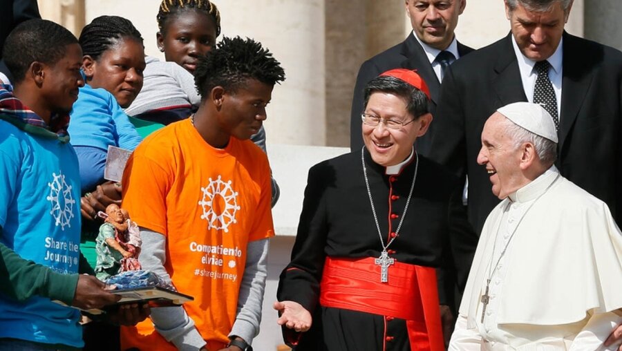 Papst Franziskus mit Kardinal Luis Antonio Tagle (z.v.r.) und Migranten / © Paul Haring (KNA)