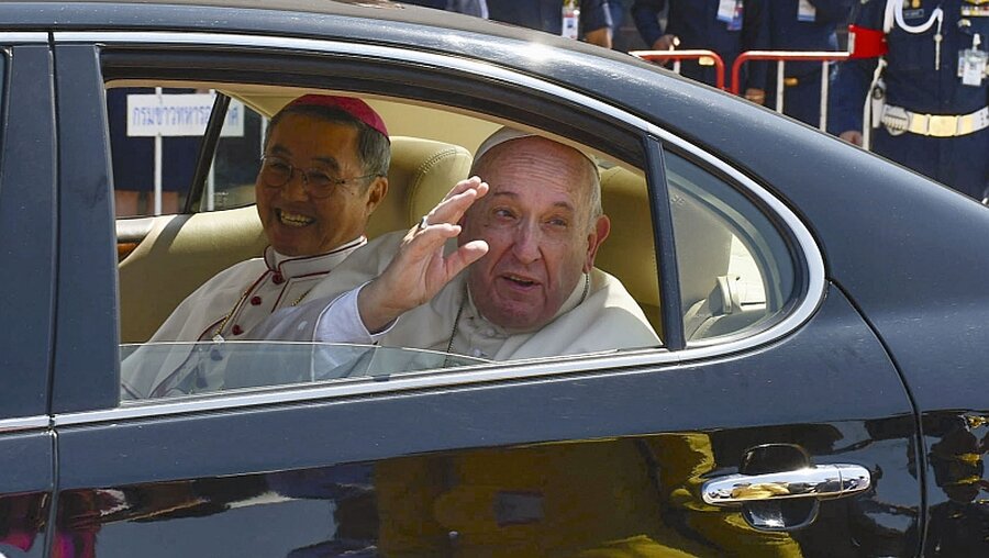 Papst Franziskus winkt aus einer Limousine, als er in Bangkok ankommt. / © N.N. (dpa)