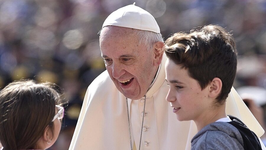 Papst Franziskus im Gespräch mit zwei Kindern / © EPA/GIORGIO ONORATI  (dpa)