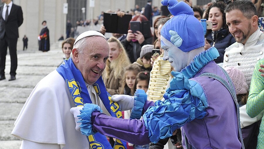 Franziskus bekommt von einem Zirkusartisten einen Schal geschenkt / © Osservatore Romano (dpa)