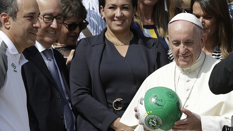 Papst Franziskus bekommt nach der Generalaudienz einen Fußball von Mitgliedern des brasilianischen Verein Chapecoense, die einen Flugzeugabsturz überlebt hatten / © Andrew Medichini (dpa)