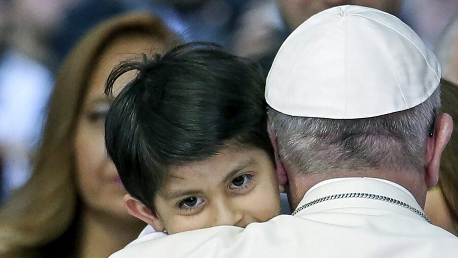 Franziskus mit Kind auf dem Arm / © ALESSANDRO DI MEO (dpa)