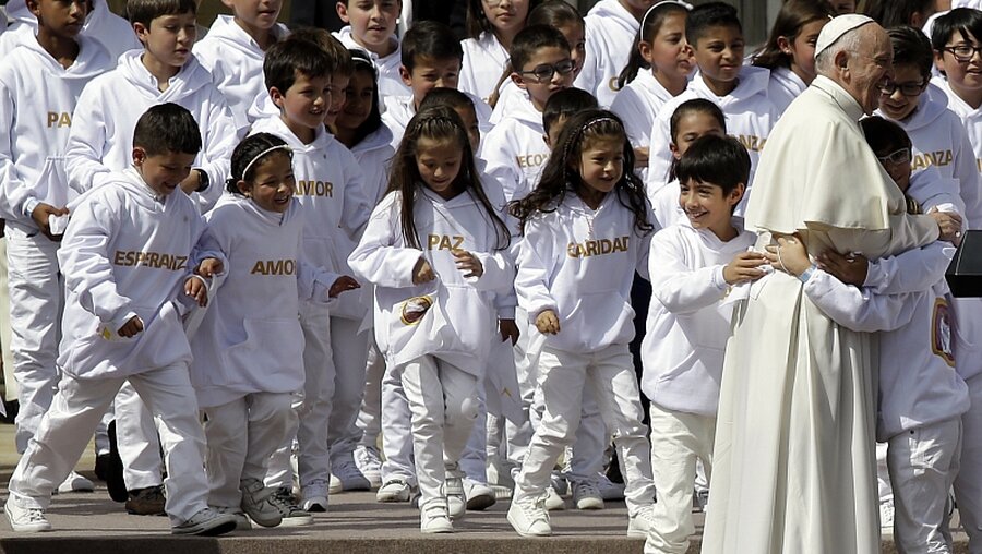 Papst Franziskus wird von Kindern in Bogota (Kolumbien) umarmt. / © Fernando Vergara (dpa)