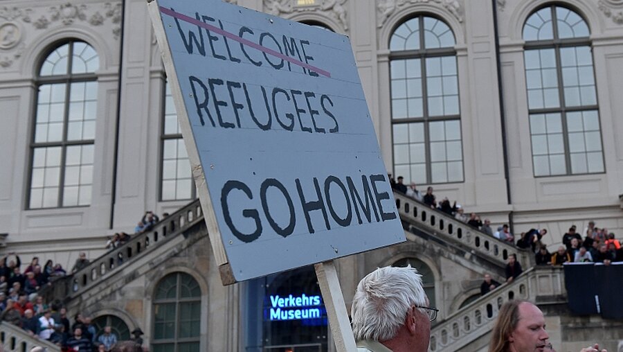 Pegida-Plakat in Dresden: "Flüchtlinge geht nach Hause" / © Bernd Settnik (dpa)