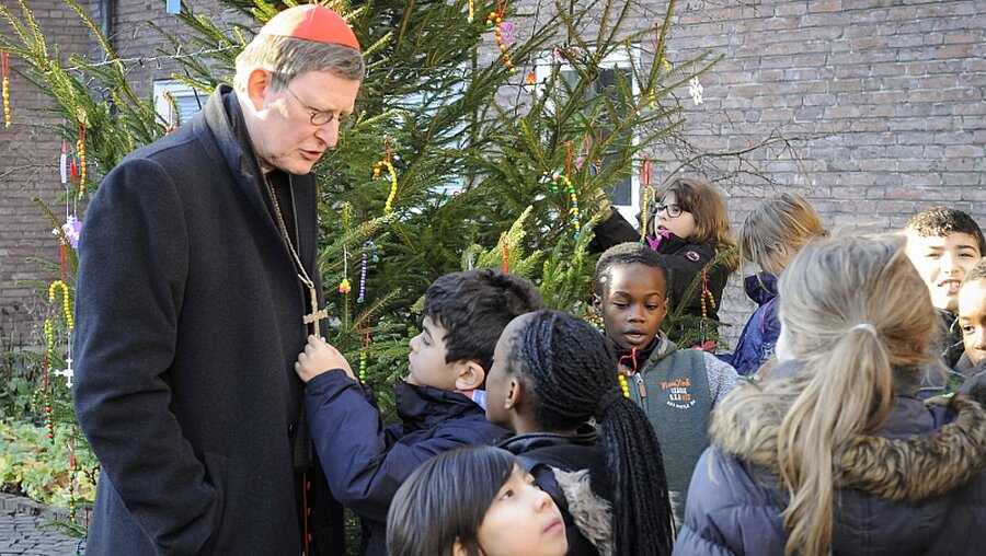 Neugierig betrachtet ein Schüler der KSG Heßhofstraße das Holzkreuz von Kardinal Woelki. (Erzbistum Köln)