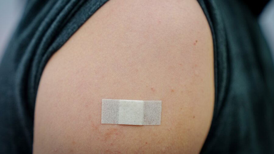 Pflaster klebt auf einer Einstichstelle nach Impfung / © Kay Nietfeld (dpa)