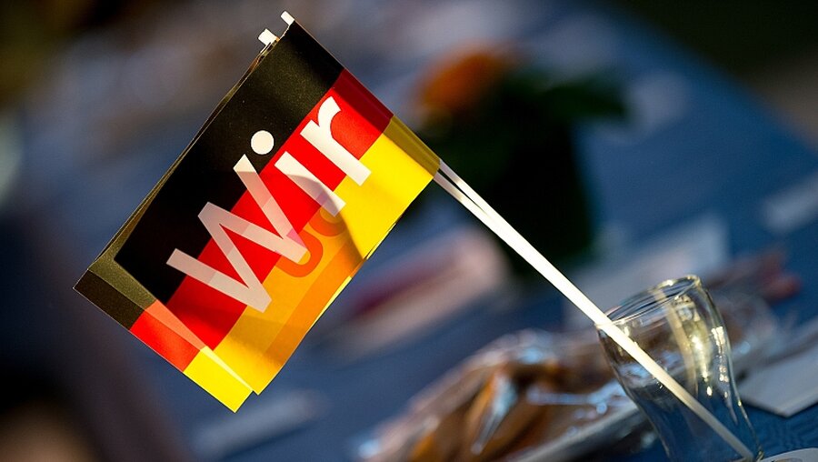 Deutschland-Flagge mit der Aufschrift "Wir" / © Swen Pförtner (dpa)