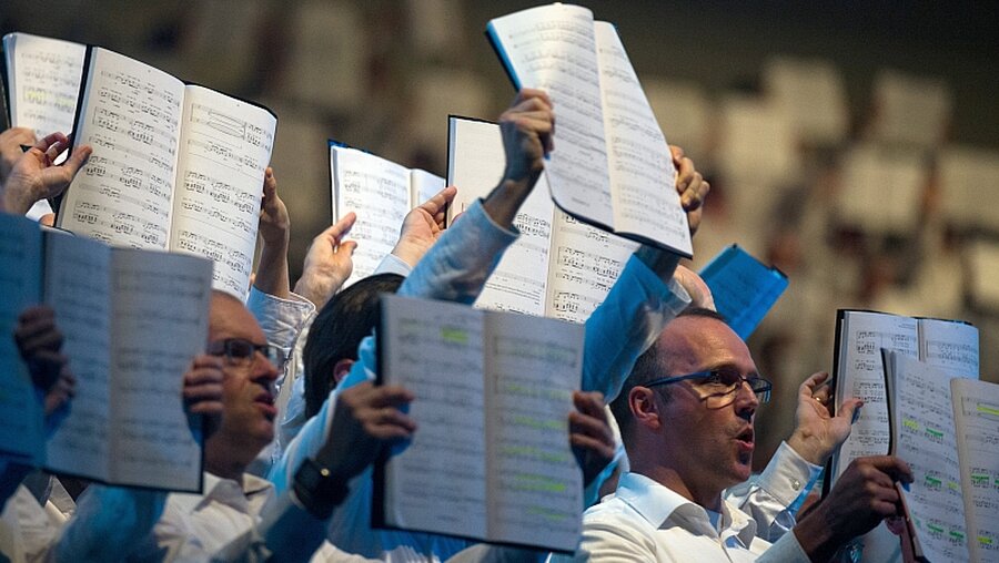 Chor singt bei der Urauführung des Pop-Oratoriums "Luther - das Projekt der tausend Stimmen"  / © Monika Skolimowska (dpa)