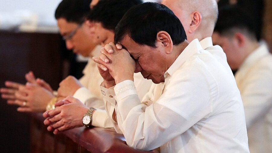 Philippinens Präsident Duterte (v.) im Gebet / © King Rodriguez / Ppd / Handout (dpa)