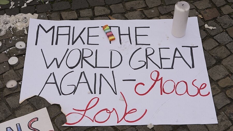 "Make the world great again, choose love", steht auf einem Zettel vor der US-Botschaft in Berlin / © Paul Zinken (dpa)