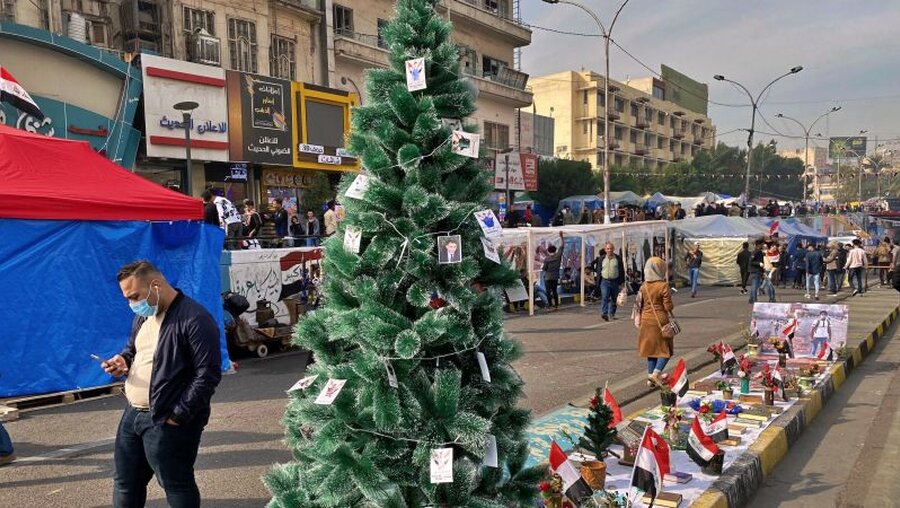 Proteste im Irak – An einem Weihnachtsbaum hängen Bilder von regierungskritischen Demonstranten, die während Zusammenstößen mit Sicherheitskräften gestorben sind / © Khalid Mohammed (dpa)