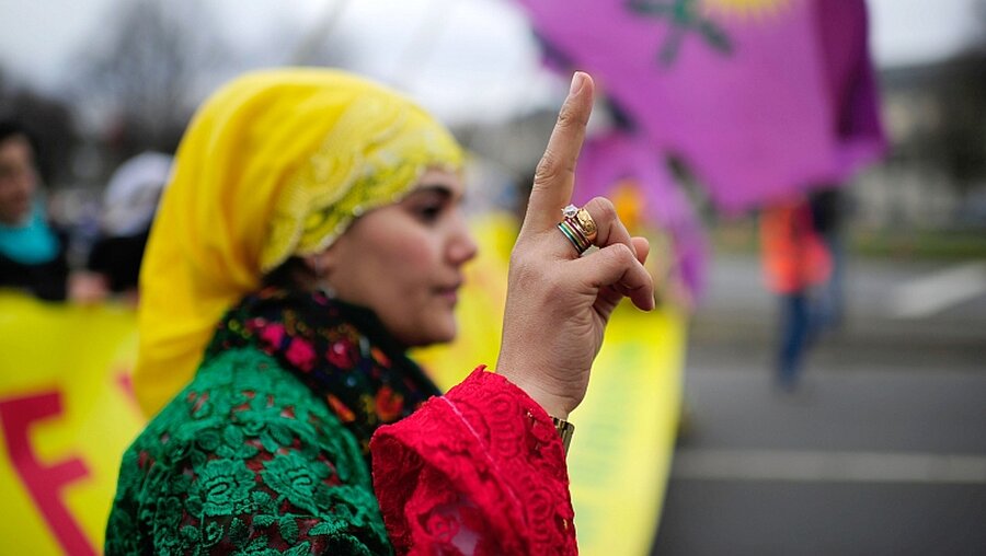Eine kurdische Demonstrantin feiert Newroz / © Alexander Körner (dpa)