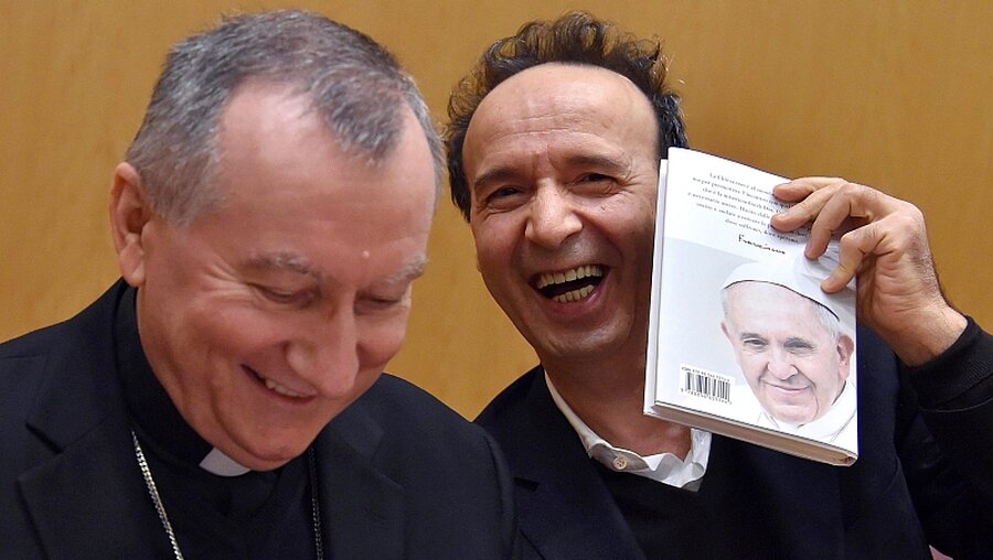 Kardinal Parolin (l) und Schauspieler Benigni mit Papstbuch  / © Ettore Ferrari (dpa)