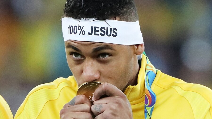 Brasiliens Neymar küsst die gerade gewonnene Medaille.  / © Alejandro Ernesto (dpa)
