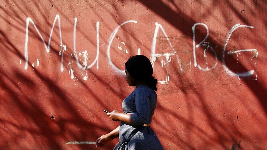 Simbabwe: Frau vor einer Mauer mit dem Graffitti-Schriftzug "Mugabe" / © Tsvangirayi Mukwazhi (dpa)