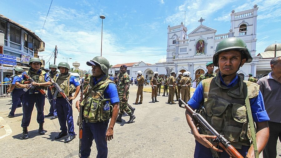 Soldaten und Polizisten sichern das Gebiet rund um eine Kirche / © Chamila Karunarathne (dpa)