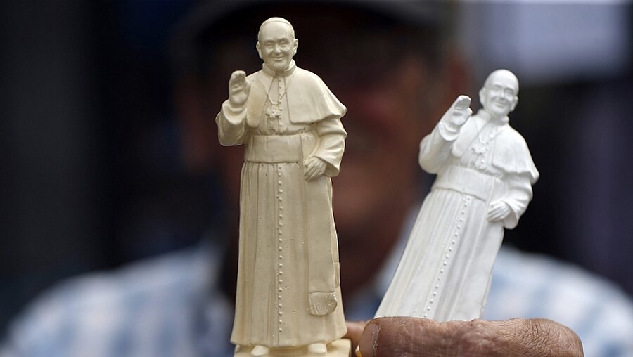 Straßenverkäufer bietet Figuren mit Papst Franziskus an / © Luis Hidalgo (dpa)