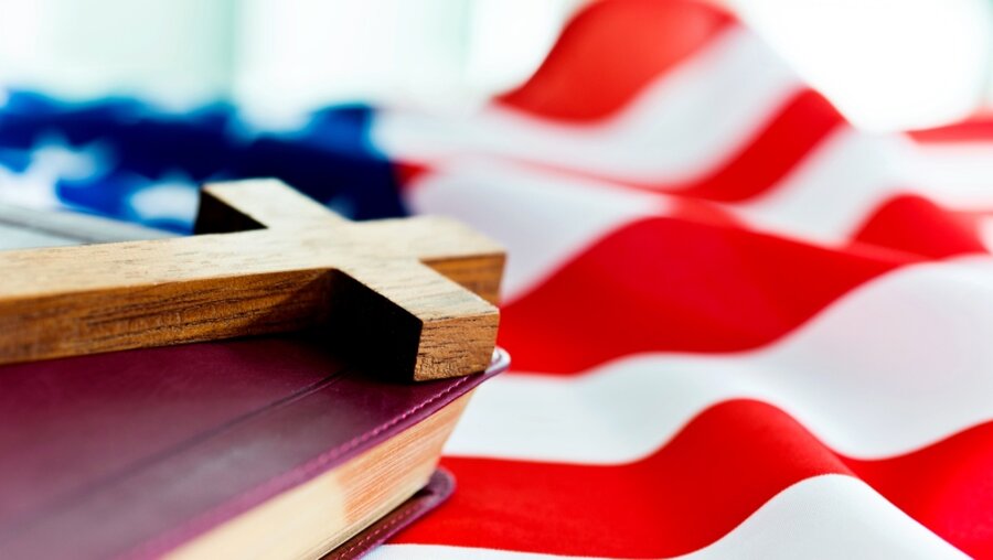 Symbolbild: Bibel und Kreuz auf us-amerikanischer Flagge / © hxdbzxy (shutterstock)