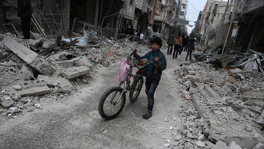 Syrisches Kind in Ost-Ghuta inmitten von Trümmern / © Samer Bouidani (dpa)