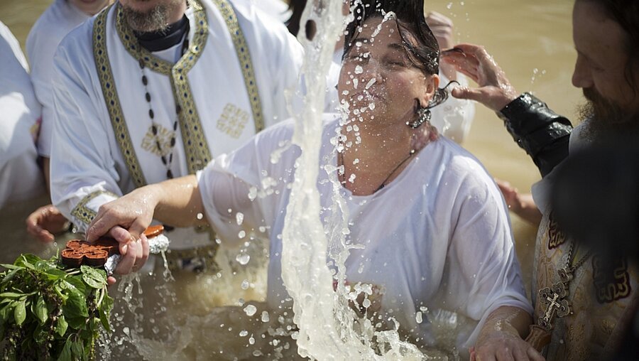 Taufe im Jordan  / © Ariel Schalit (dpa)