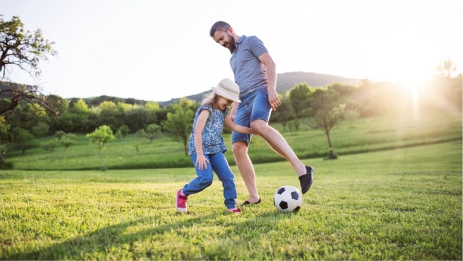 Symbolbild: Tochter und Vater spielen Fußball / © Halfpoint (shutterstock)