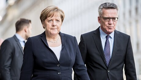 Die ehemalige Bundeskanzlerin Angela Merkel (CDU) und der ehemalige Bundesinnenminister Thomas de Maiziere. / © Michael Kappeler (dpa)