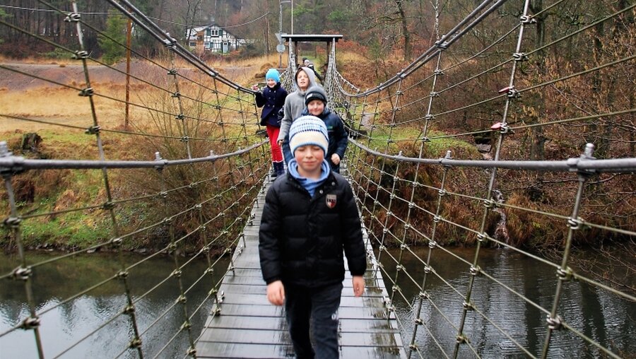 Über eine Wackelbrücke überqueren die Kinder den Fluss - fast wie auf dem See Genezareth. / © Küppers (DR)