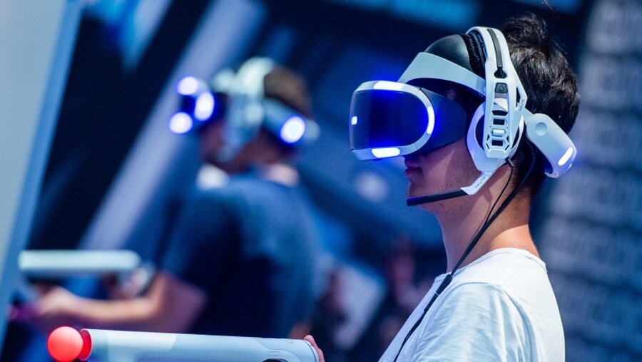 Videospieler mit einer VR-Brille / © Christophe Gateau (dpa)