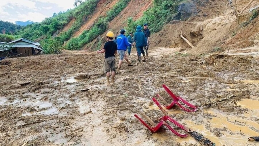 Vietnam, Quang Nam: Dorfbewohner waten durch Schlamm, nachdem ein Erdrutsch ein Dorf überschwemmt hat. / © Lai Minh Dong/VNA/AP (dpa)