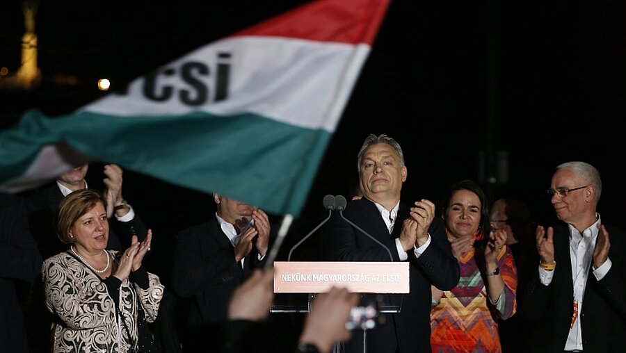 Viktor Orban (Fidesz-Partei), EU-kritischer Ministerpräsident Ungarns, klatscht mit seinem Team und seinen Unterstützern während einer Ansprache nach der gewonnenen Wahl.  / © Darko Vojinovic (dpa)