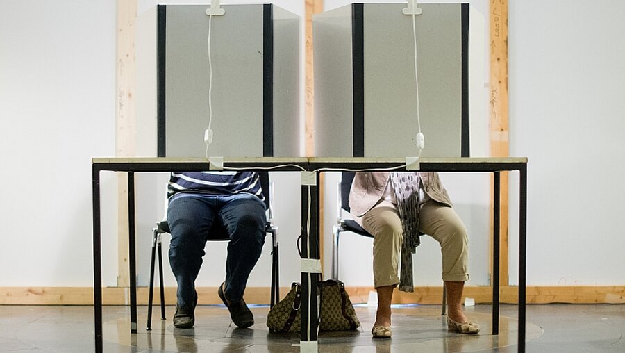 Stimmabgabe in der Wahlkabine / © Julian Stratenschulte (dpa)