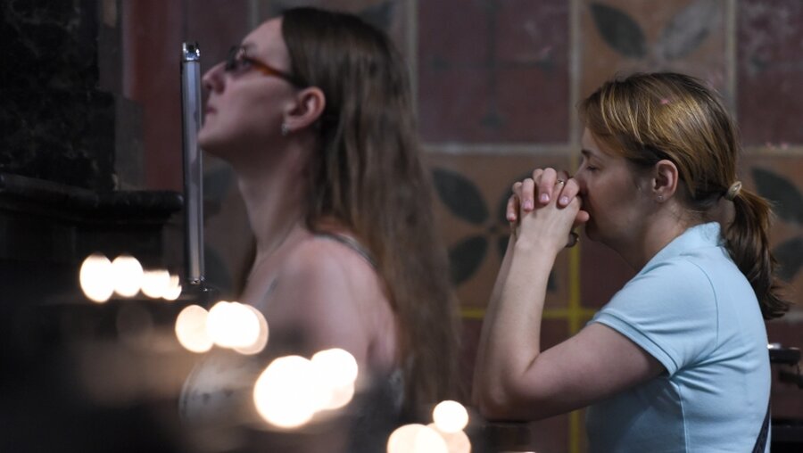 Zwei Frauen im Gebet versunken. / © Harald Oppitz (KNA)