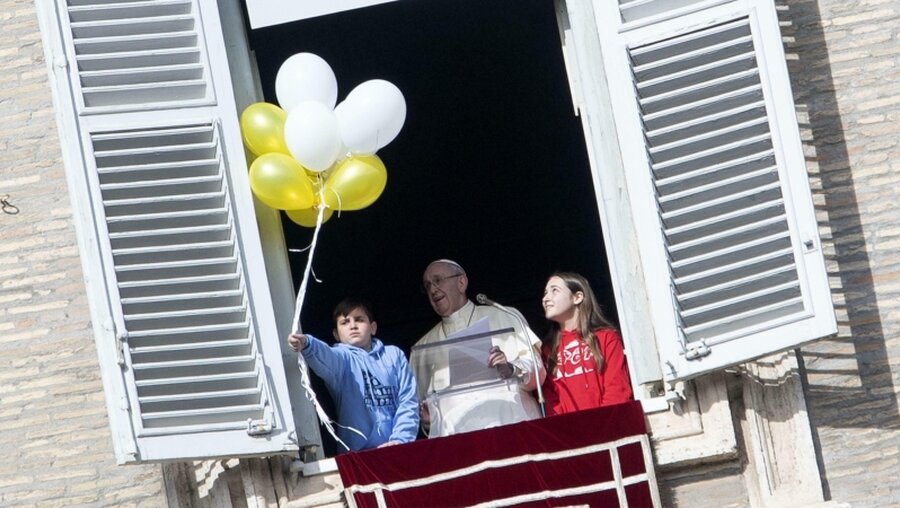 Zwei Kinder lassen während des Angelusgebets von Papst Franziskus Luftballons aus einem Fenster steigen / © Massimo Percossi (dpa)