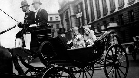 06.06.1931: Prinzessin Elisabeth, heute Königin Elisabeth II., sitzt neben Königin Mary und der damaligen Herzogin von York in einer Kutsche / © Pa/PA Wire (dpa)