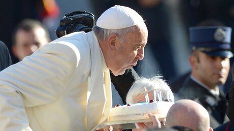 Papst Franziskus bläst die Kerzen einer Geburtstagstorte 2014 (KNA)
