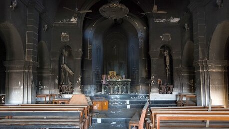 Innenansicht mit Blick auf den Altarraum der teilweise zerstörten christlichen syrisch-katholischen Kirche Sankt Georg in Bartella. / © Uygar Onder Simsek (KNA)