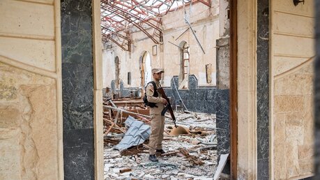 Blick durch das Eingangsportal in eine zerstörte christliche Kirche in Karakosch. / © Uygar Onder Simsek (KNA)