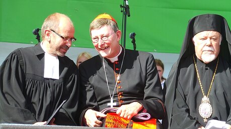 Kardinal Woelki (m.) mit dem rheinischen Präses Manfred Rekowski (l.) und dem griechisch-orthodoxen Metropolit von Deutschland, Augoustinos)  / © Verena Tröster  (DR)