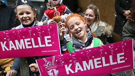 Kinder zeigen beim Rosenmontagszug in Köln Banner mit der Aufschrift "Kamelle" / © Rolf Vennenbernd (dpa)