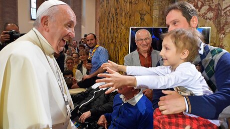 Papst Franziskus begrüßt lachend ein kleines Mädchen / © Osservatore Romano (KNA)