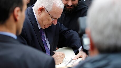 Israels Präsident Reuven Rivlin trägt sich in das Gästebuch von Tabgha ein / © Corinna Kern (dpa)
