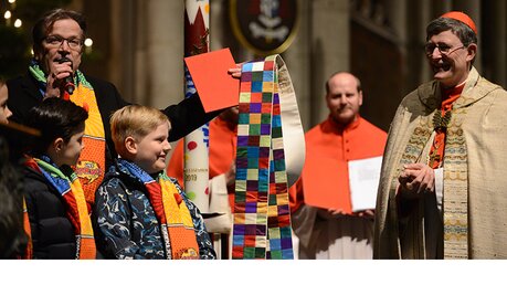 Christoph Kuckelkorn, Präsident des Festkomitees Kölner Karneval, überrascht den Erzbischof mit einer Stola nach Richter-Manier. / © Tomasetti (DR)