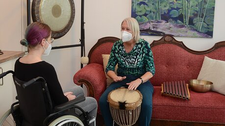 Im Wohnzimmer des Bensberger Hospizes probiert die Gestalttherapeutin verschiedene Instrumente mit einer Patientin aus. / © Beatrice Tomasetti (DR)