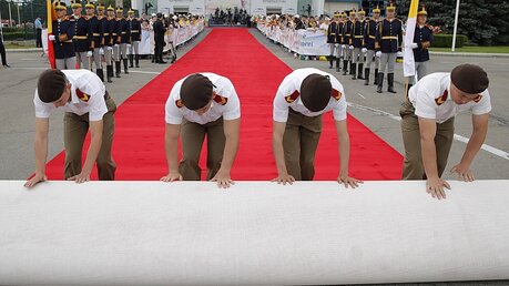 Ein roter Teppich wird vor der Ankunft des Papstes am Flughafen Bukarest Henri Coanda ausgerollt. / © Vadim Ghirda (dpa)