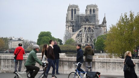Fußgänger und Radfahrer betrachten die Kathedrale Notre-Dame / © Victoria Jones (dpa)