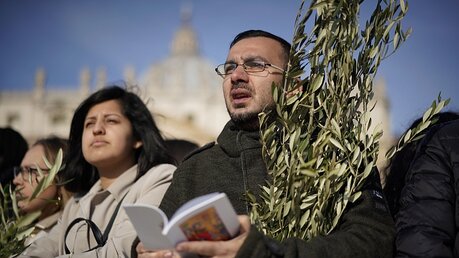 Gläubige beten bei der Messe am Palmsonntag auf dem Petersplatz / © Andrew Medichini (dpa)