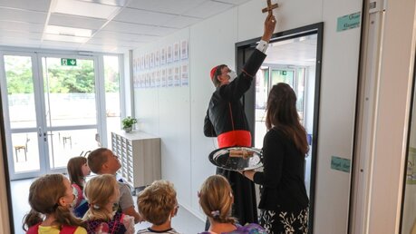 Holzkreuze werden im Vorraum und in den Klassenzimmern der neuen Grundschule in Köln-Kalk aufgehängt.  / © Schoon (Erzbistum Köln)